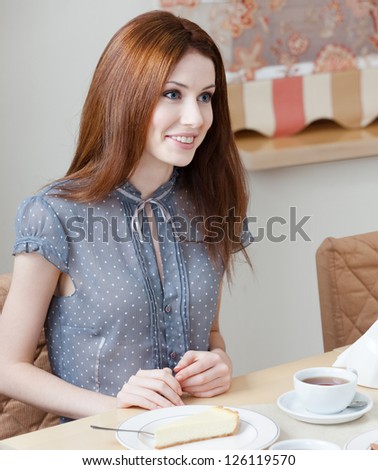 Woman talks with someone sitting at the table at the coffee house