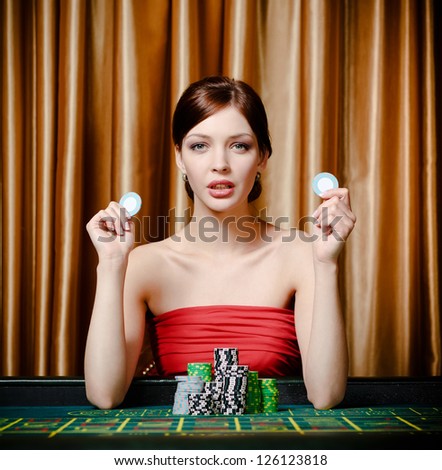 Woman with chips sitting at the roulette table at the casino club