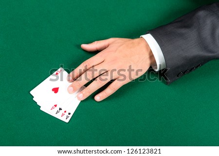 Hand with aces on the green table. Challenge to the casino