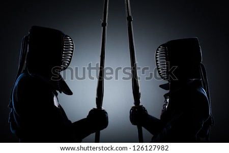 Two kendo fighters opposite each other with shinai. Japanese martial art of sword fighting