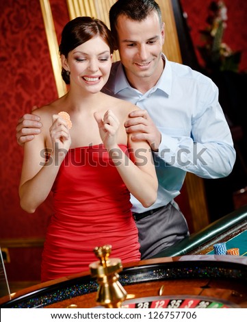 Couple playing roulette follows the game at the casino