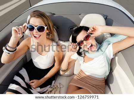Top view of happy women with sunglasses sitting in the cabriolet