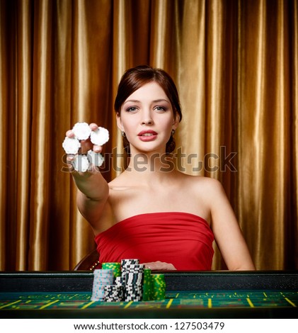 Female gambler keeps chips in hand sitting at the casino table