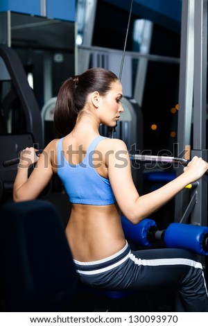 Athletic young woman works out on training apparatus