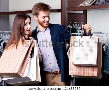 Couple with paper bags full of presents does shopping