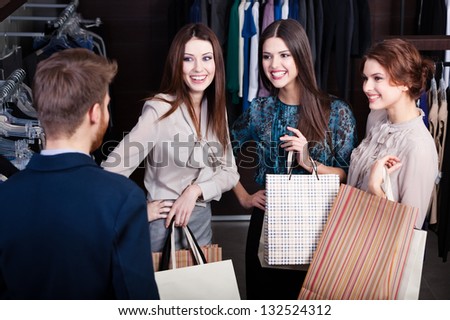 Girls consult with shop assistant of the store Girls consult with shop assistant of the store