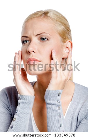 Woman examining her face and wrinkles that can appear, isolated on white