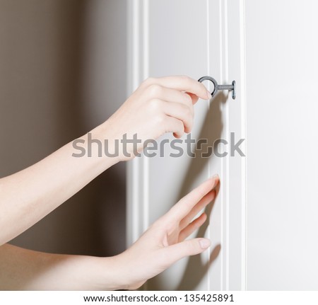 Close up of two hands opening the door with a key