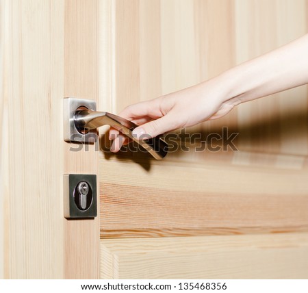 Close up of hand opening the door with door handle