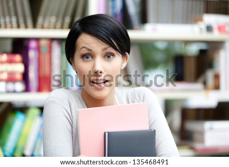 Female student with book at the library. Education and self-development