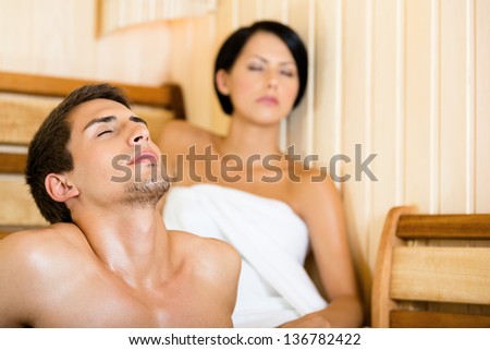Half-naked man and girl relaxing in sauna. Concept of self-care, health and relaxation