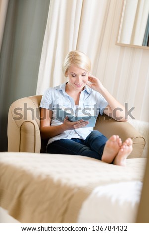 Girl sitting on the sofa reads a book. Concept of education and useful pastime