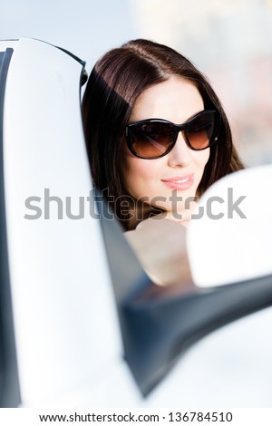 Close up of pretty female driver in the white auto