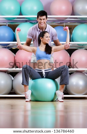 Athletic woman exercises in fitness gym with couch