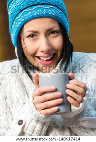 Portrait of girl drinking tea and wearing warm clothes outdoors when going in for winter sports