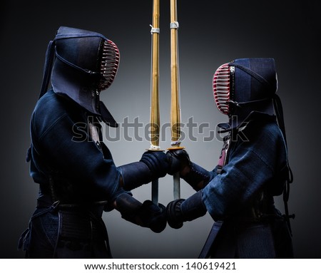 Two kendo fighters with shinai opposite each other. Japanese martial art of sword fighting