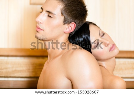 Half-naked man and girl with eyes closed sitting back to back in relaxing sauna