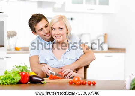 Young couple preparing breakfast sitting together at the breakfast table full of groceries