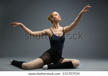 Dancing on the floor ballerina with her hand up, isolated on white on grey. Concept of elegant art and sportive hobby