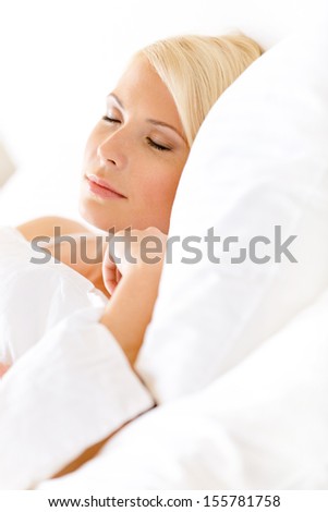 Close up view of sleepy woman in bed lying on the white cushion