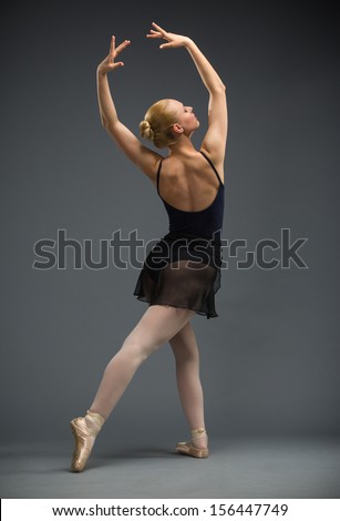 Full-length portrait of dancing ballerina with hands up, isolated on white background on grey. Concept of elegant art and sportive hobby