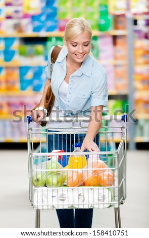Girl With Cart Full Of Food In The Shop. Concept Of Consumerism, Retail And Purchase