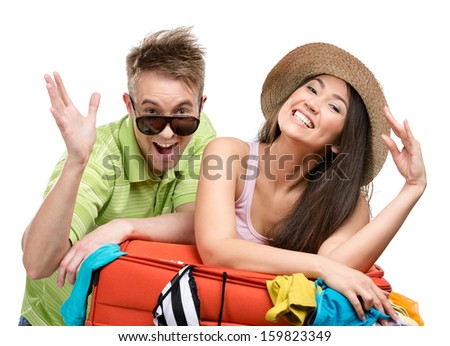 Couple packs up suitcase with clothing for travel, isolated on white. Concept of romantic vacations and lovely honeymoon