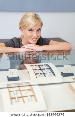 Consultant at the window case with rings at jeweler\'s shop. Concept of wealth and luxurious life
