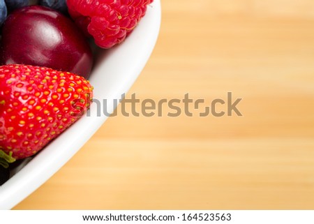 Close up shot of part of plate full of berries on the table. Concept of healthy eating and dieting lifestyle
