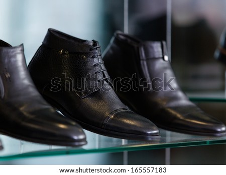 Close up of set of male shoes at the showcase in the shopping mall