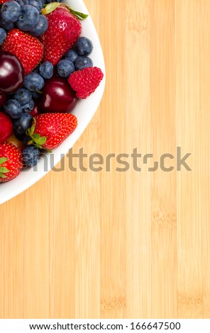 Close up of part of plate full of berries on the table. Concept of healthy eating and dieting lifestyle