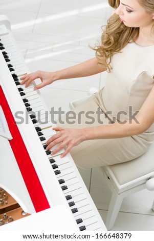 Top view of woman playing piano. Concept of music and arts