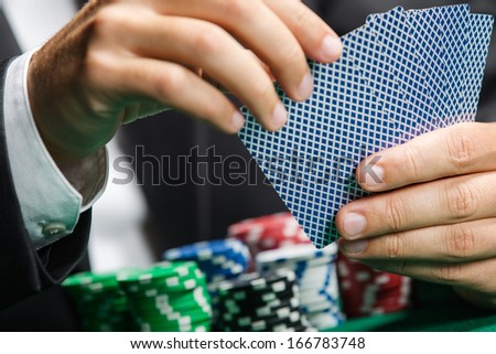 Gambler playing poker cards with poker chips on the poker table. Risky entertainment of gambling