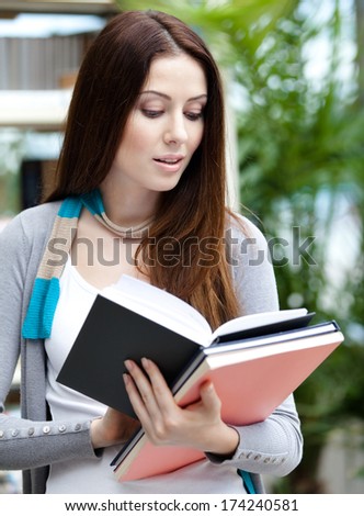 Young female student with books at the library. Research. Education