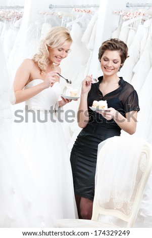 Shop assistant and the bride eat a delicious cake selebrating a good decision