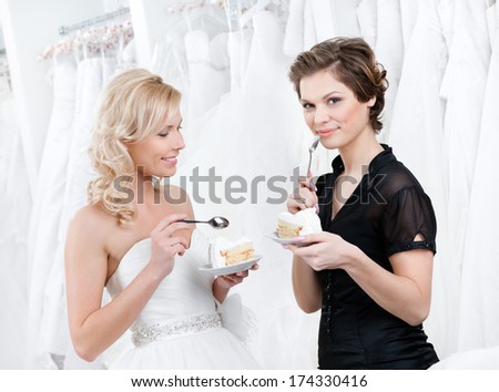 Shop assistant and the bride eat an amazing wedding cake