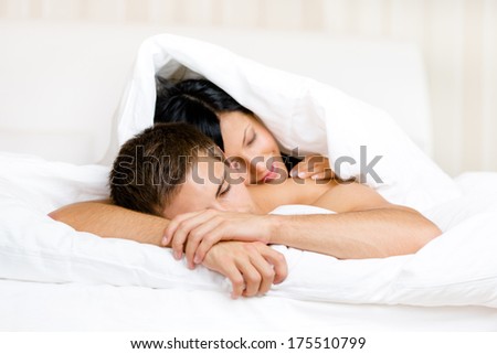 Woman sleeps on man in bed covered with blanket. Concept of love and affection