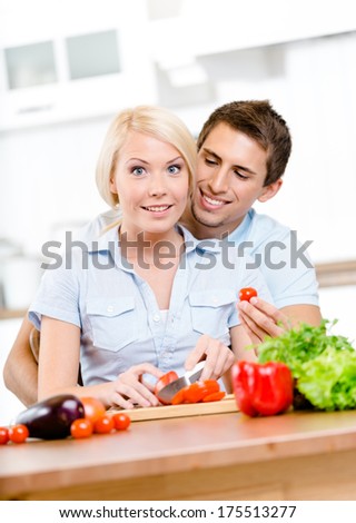 Married couple preparing breakfast sitting together at the breakfast table full of vegetables