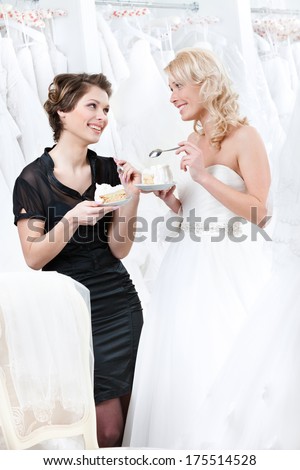 Shop assistant and the bride eat a pie selebrating a good decision