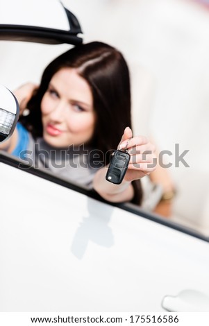 Girl in the white car shows car key. Buying car and getting the freedom