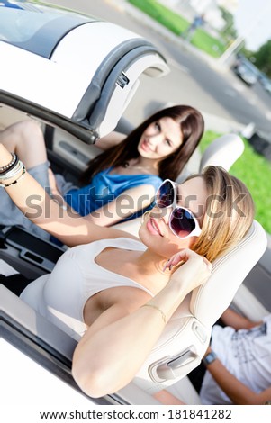 Two girls drive the car. Teenagers have a little trip on vacation