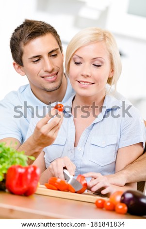 Young couple preparing breakfast sitting together at the breakfast table full of vegetables