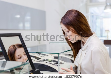Girl choosing jewelry at jeweler\'s shop. Concept of wealth and luxurious life