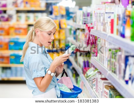 Amazed girl at the store choosing cosmetics among the great variety of products. Concept of consumerism, retail and purchase