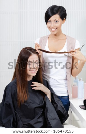 Hair stylist cuts hair of woman in hairdress salon. Concept of fashion and beauty