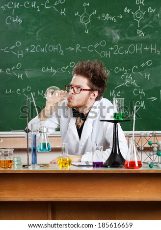 Mad professor drinks the liquid in the vial in his laboratory