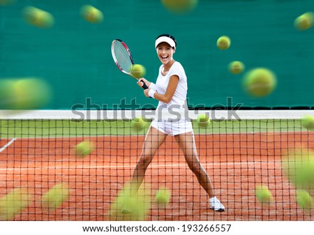 Sports woman returning lots of balls at the tennis court. Concept of tournament preparation and healthy lifestyle
