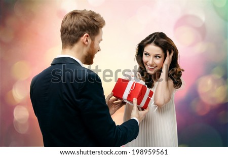 Man makes present to his lovely sweetheart on abstract and fantasy background