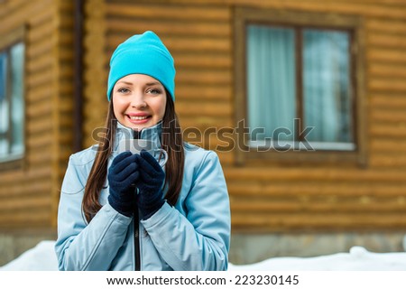 Portrait of woman drinking tea and wearing warm clothes outdoors when going in for winter sports