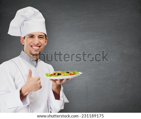 Chef cook with vegetable salad dish thumbs up, grey background